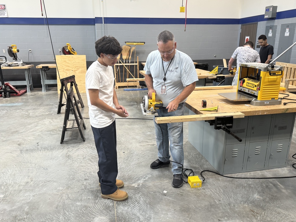 Students learning from the teacher proper skill saw techniques
