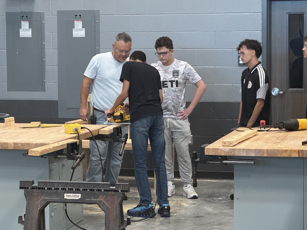 Students learning from the teacher proper skill saw techniques