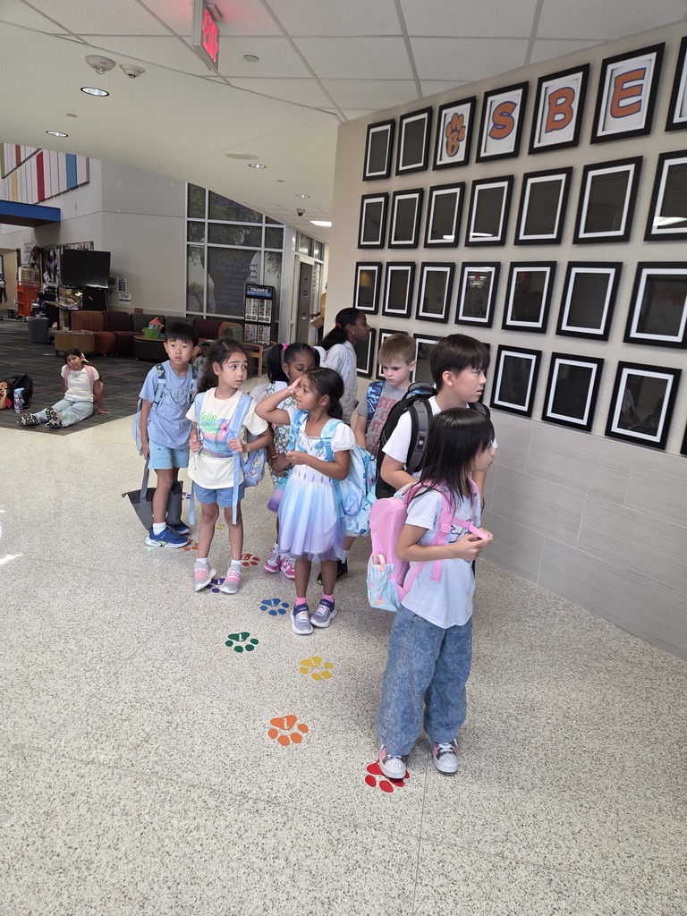 Students standing on colored paw prints to help with organization in disimissal.