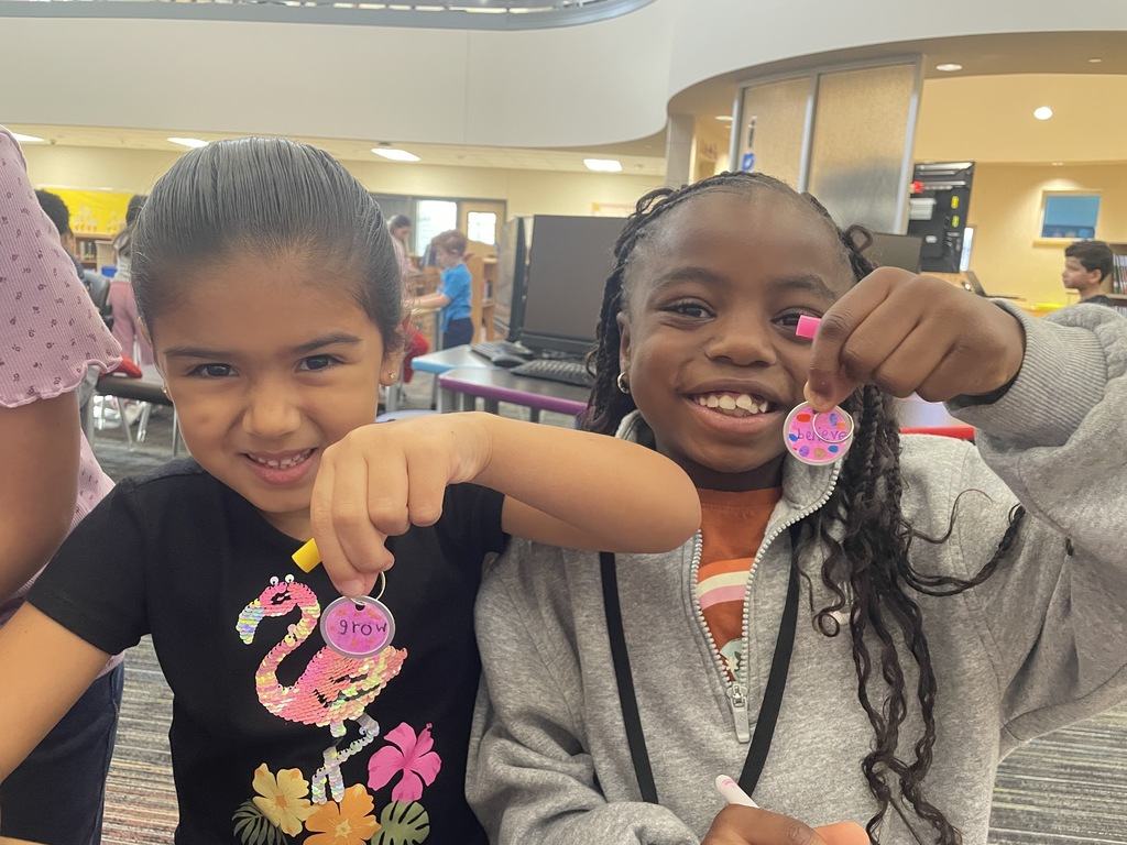 Students showing the keychains they made for dot day.