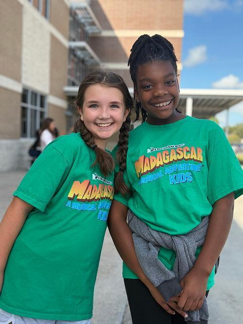 Two students posing in their district musical tshirts