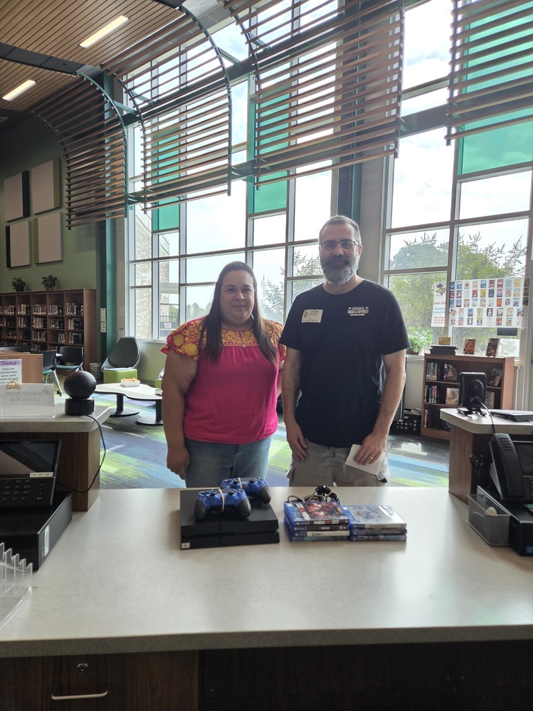 Mrs. Treviño, librarian & Mr. Wicks from Player 1 with new gaming system donation