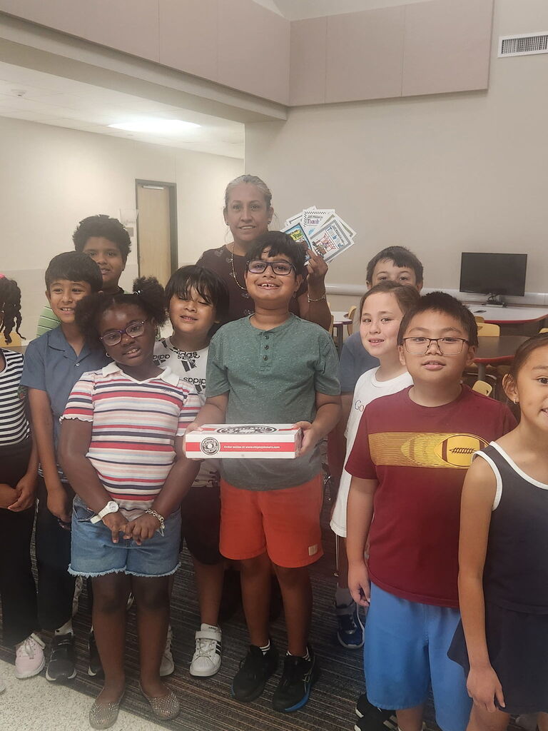 Second graders posing with one of our custodian with donuts and notes for national custodian day.