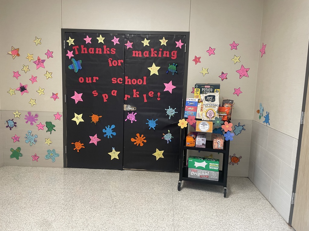 The custodians' office door covered in black paper and stars with a sign saying thanks for making our school sparkle.  A cart full of treats.