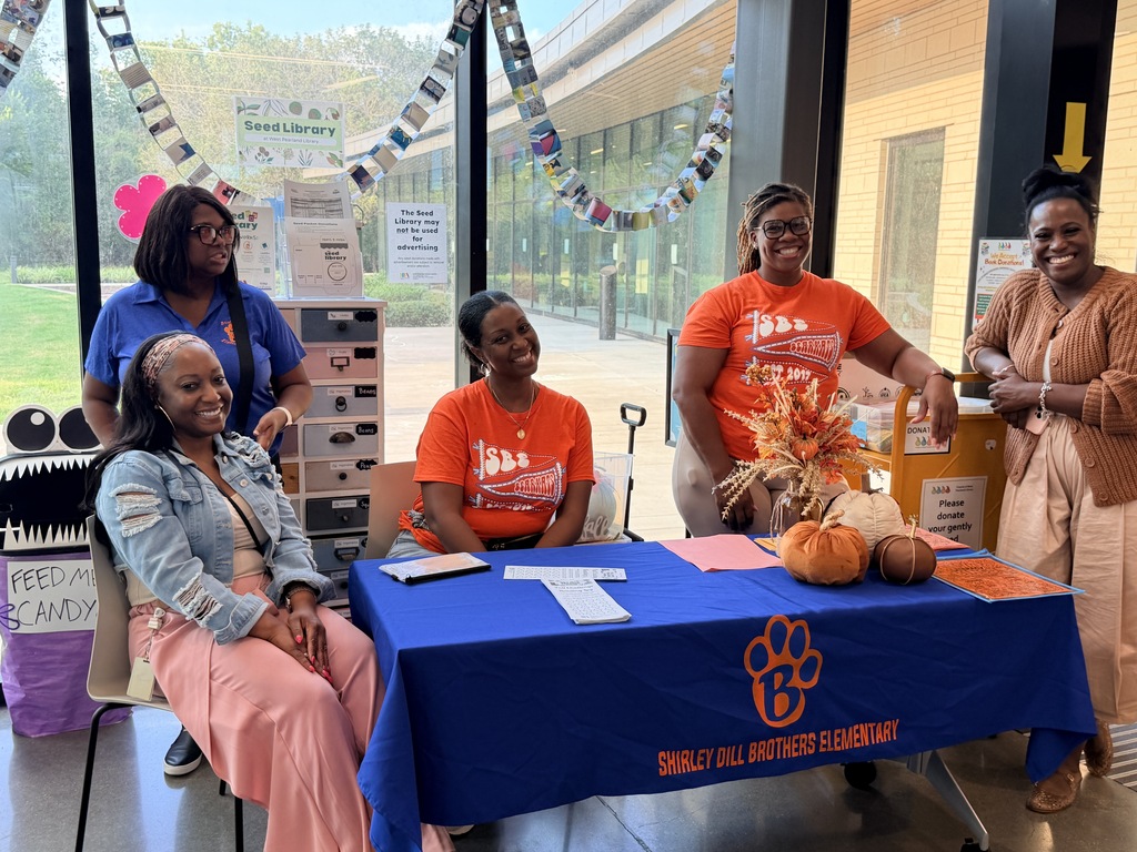 Teachers and staff welcoming students at the public library for family academic night