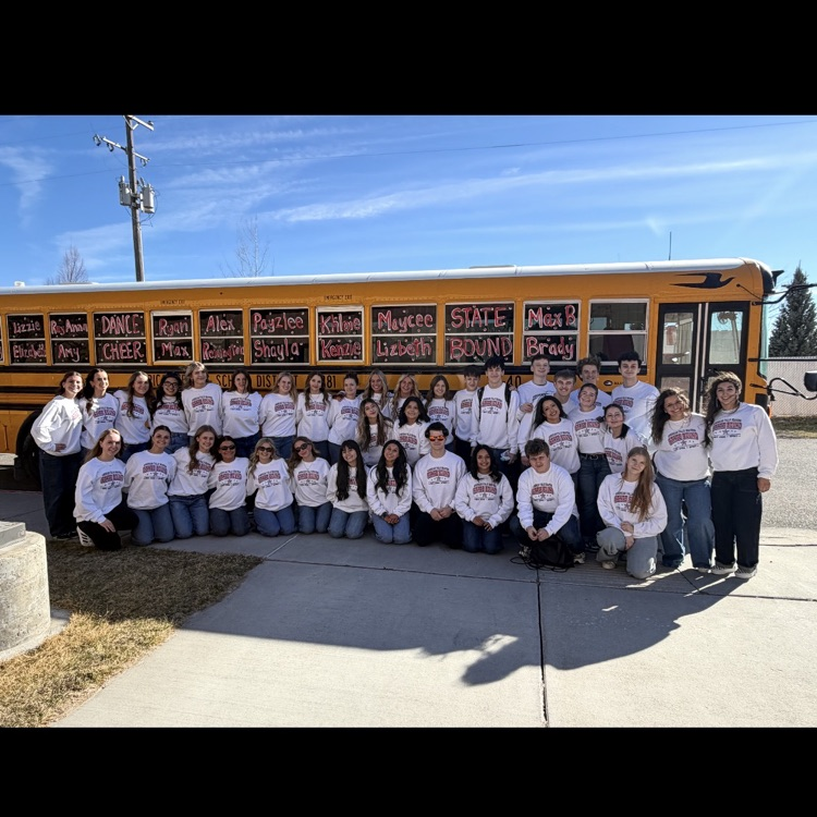 cheer and dance team standing in front of bus before they head I’d to state in Idaho falls