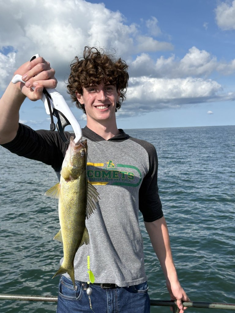 Student holding a fish on a boat 