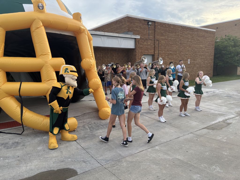 Students walking through giant football helmet