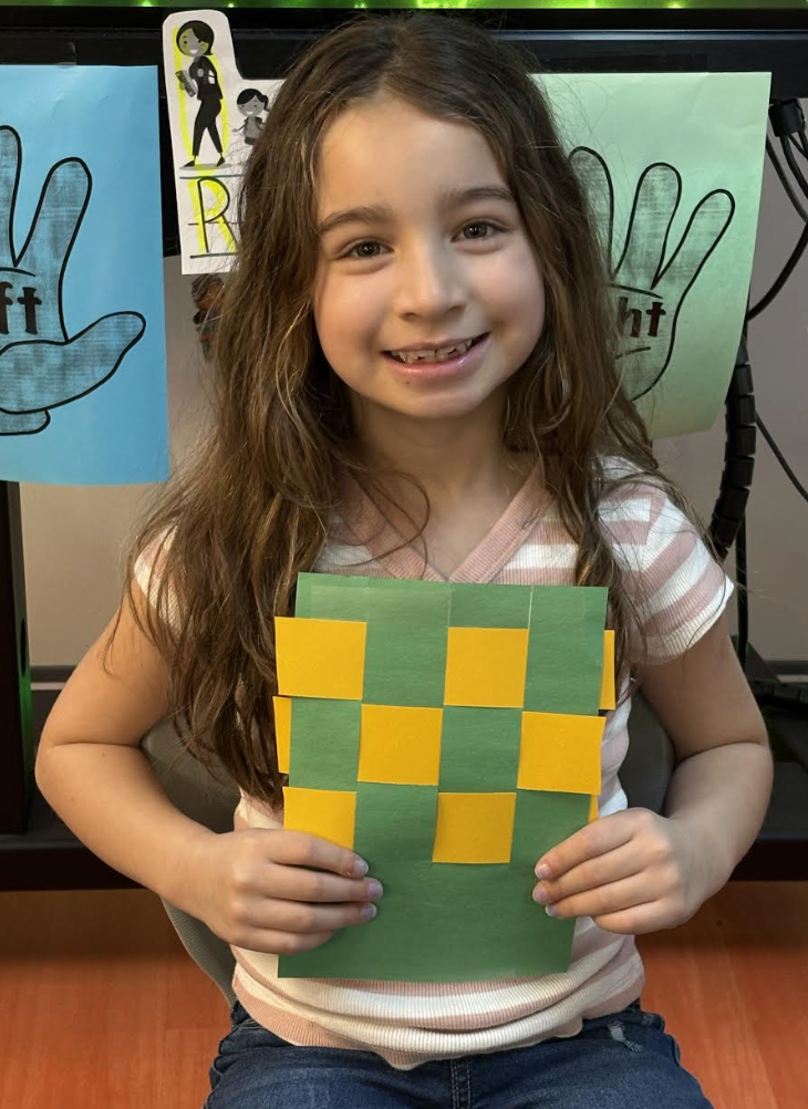 Student demonstrating basket weaving activity 