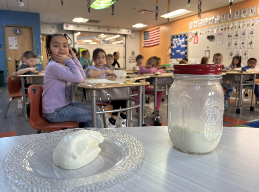 Students butter they made with students smiling behind it.