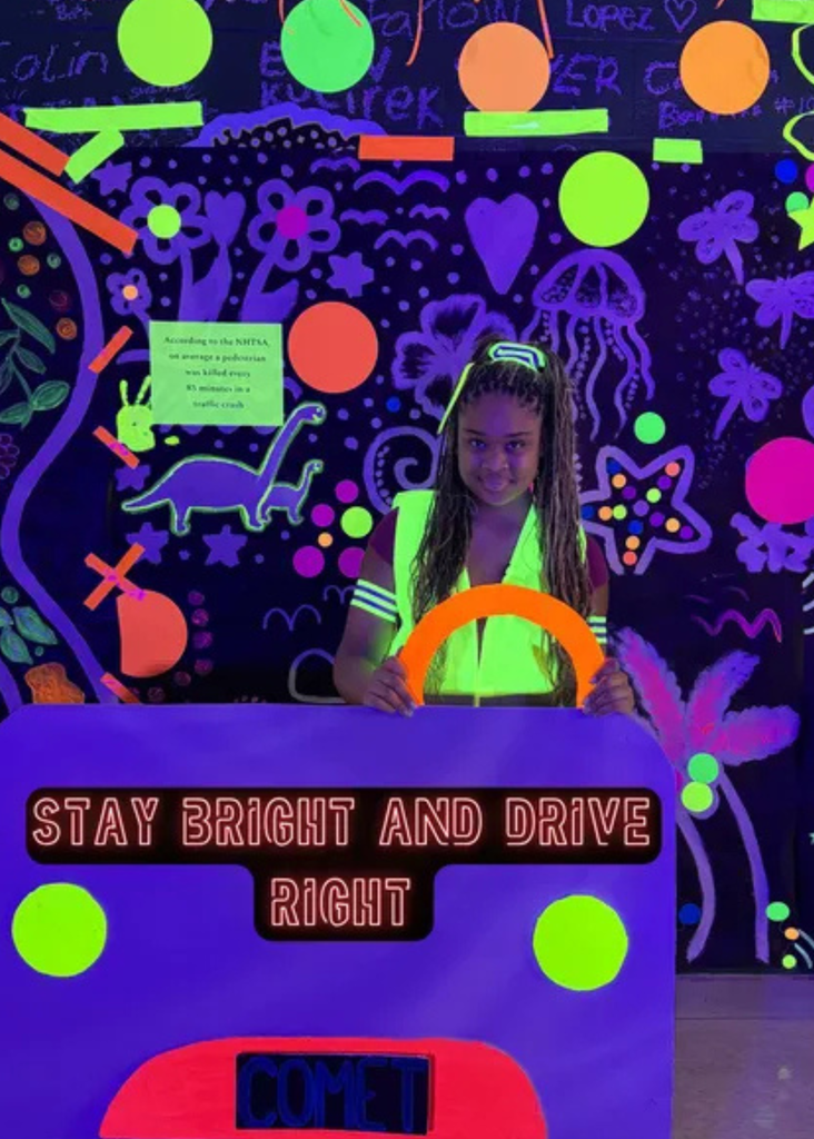 Student in neon vest promoting the Stay Bright and Drive Right Campaign