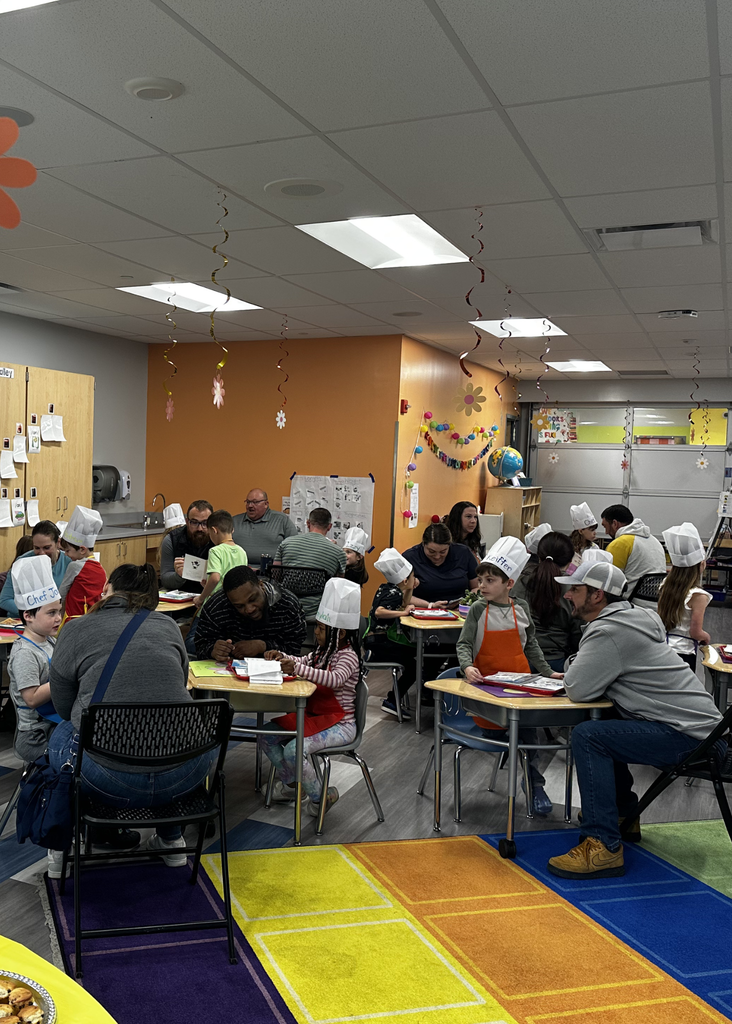 group shot of the Reading Cafe in Mrs. Escher's Kindergarten Class - parents reading with their students in chef hats