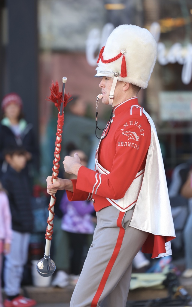 The Amherst band drum Major performs on a city Street