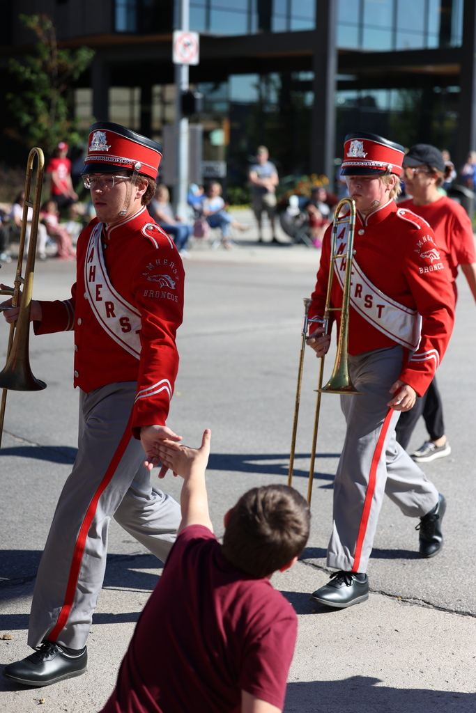 Amherst Band marches down city street, gives high-5s to crowd