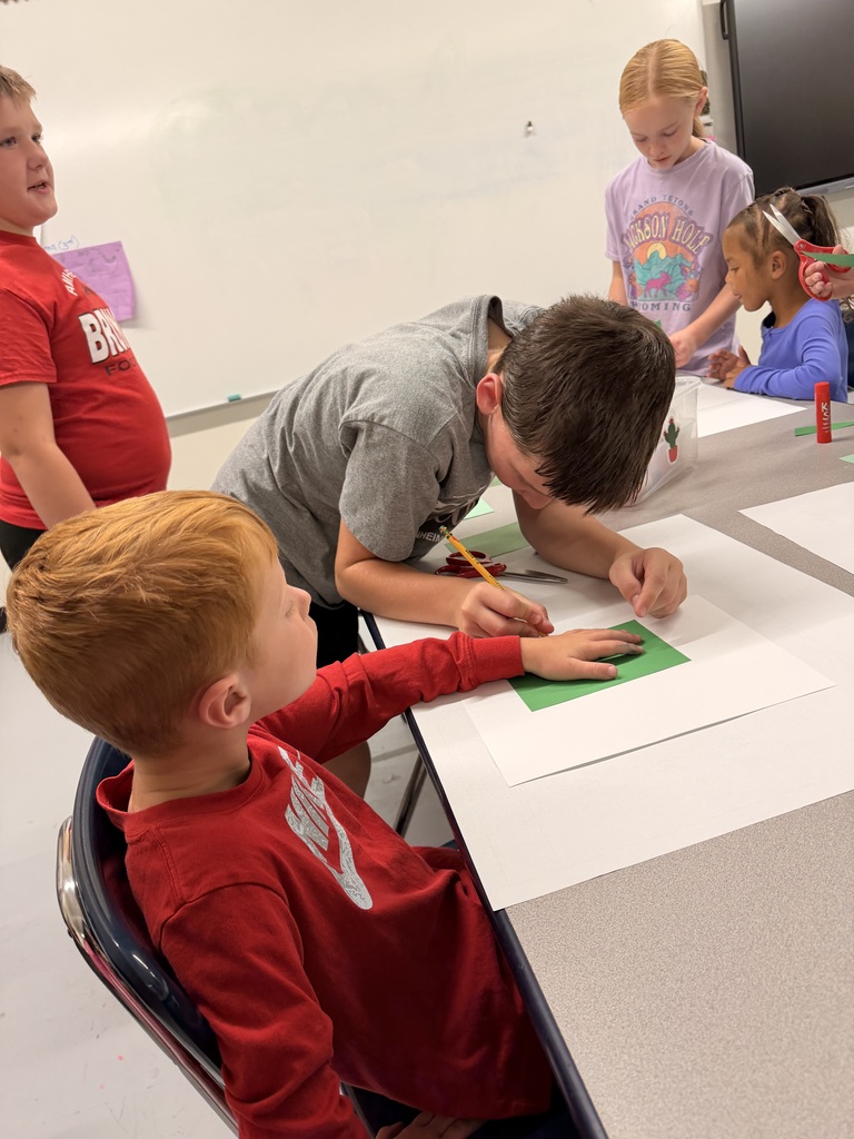 Older students help younger students create food themed artwork