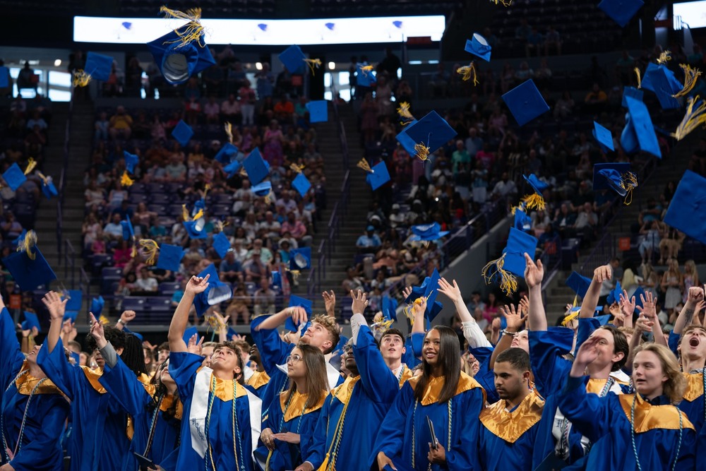 Seniors tossing their graduation caps in the air at the end of graduation