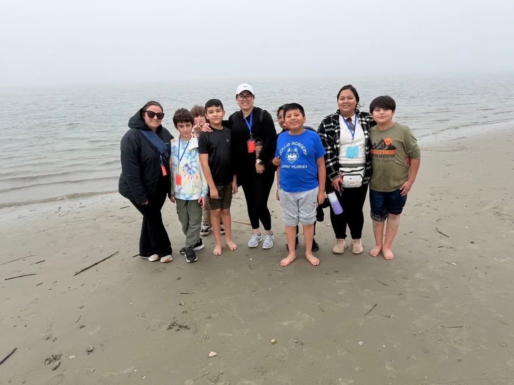 Group picture of 2 boys groups with chaperones on the beach