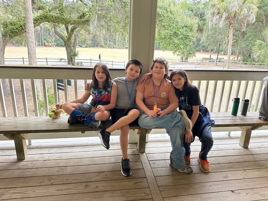 group of 5th grade boys sitting on a bench taking a break