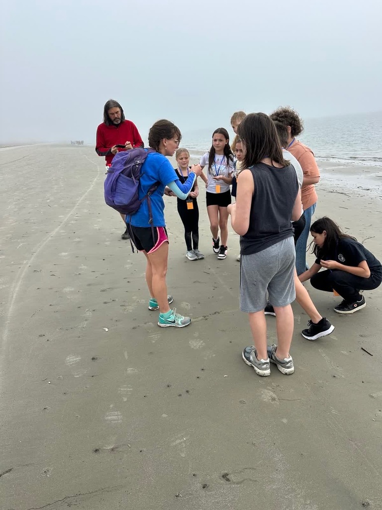 girl group with leader from B.Island explaining things on the beach
