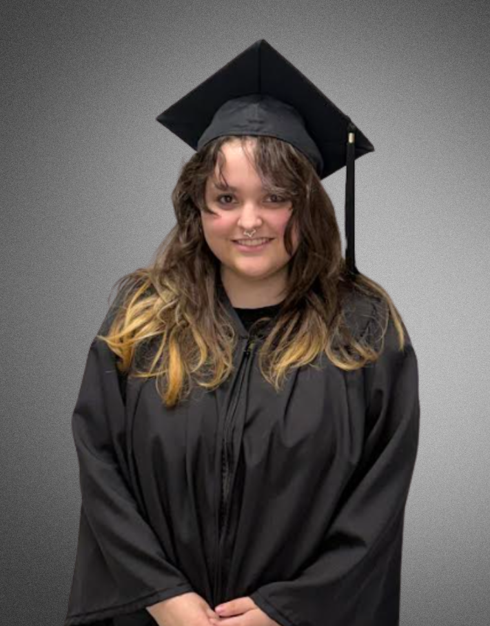a student posing for a picture in graduation cap and gown