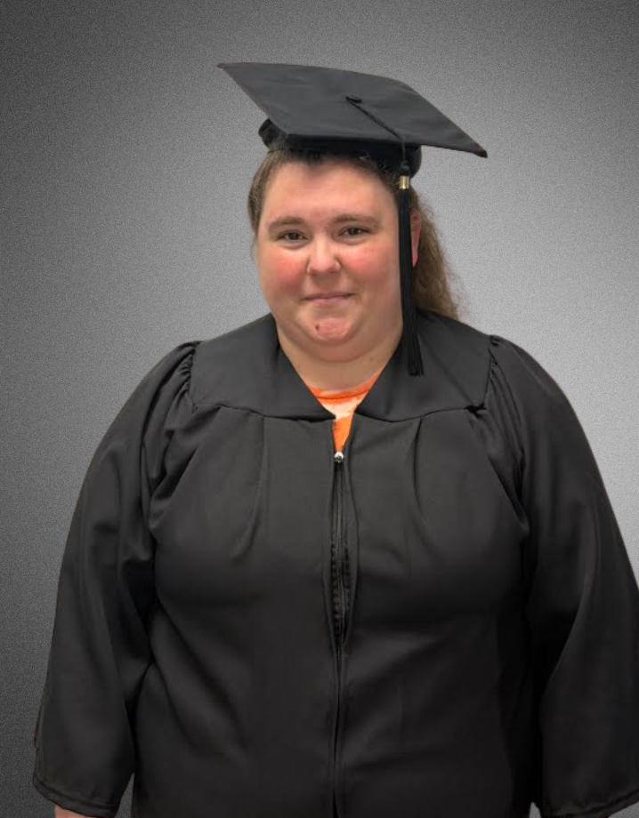 a student posing for a picture in graduation cap and gown