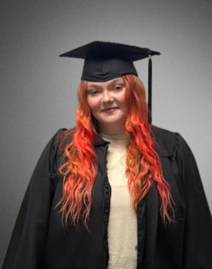 a student posing for a picture in graduation cap and gown