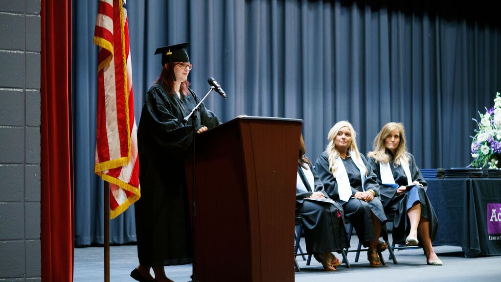 student speaking at the podium at graduation