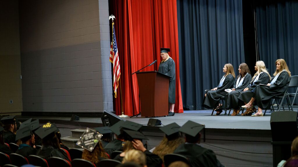 student speaking at the podium at graduation