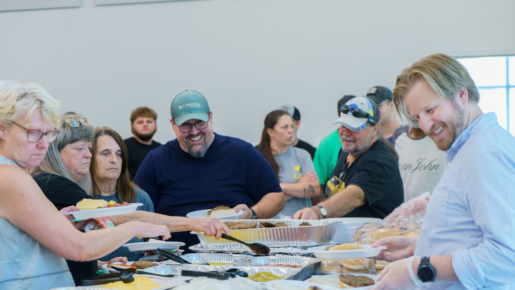 Staff members put food on their plates at the buffet table