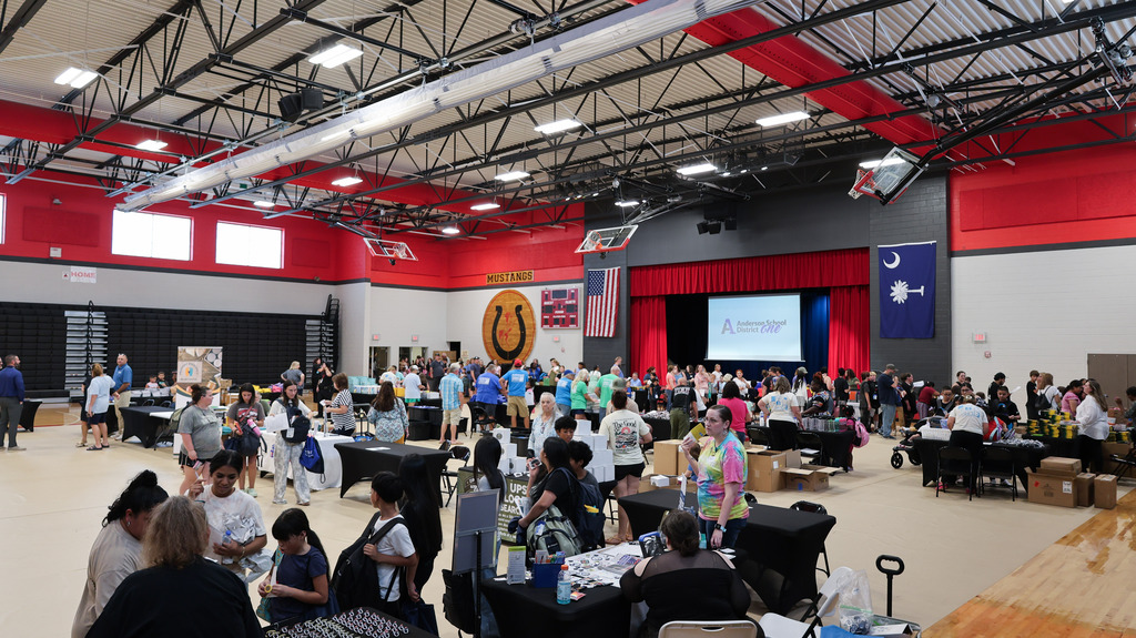 Students and families attend the Back-to-School Bash and go to tables to collect school supplies