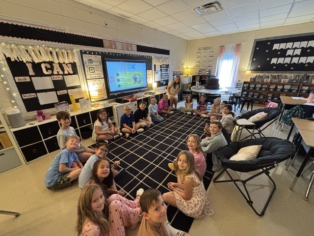 Students in a circle with teacher on the first day of school