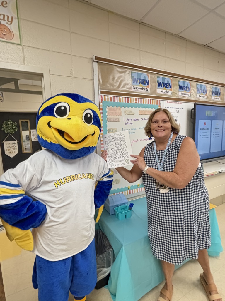 Mrs. Chapman sharing a picture of our mascot while standing with mascot.