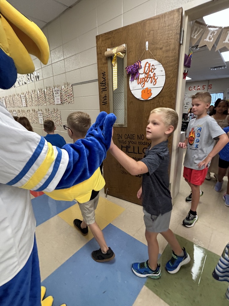 Mascot high-fiving students coming out of the classroom