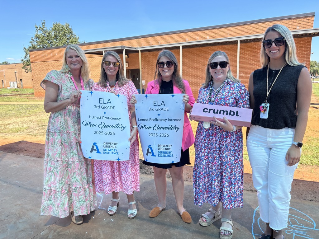 Third grade teacher receiving top performer posters