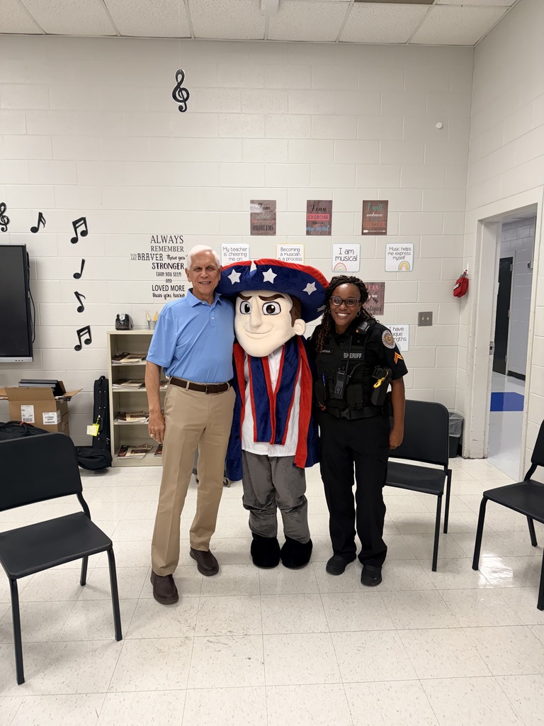 The former school principal and SRO posing for a picture with the school mascot