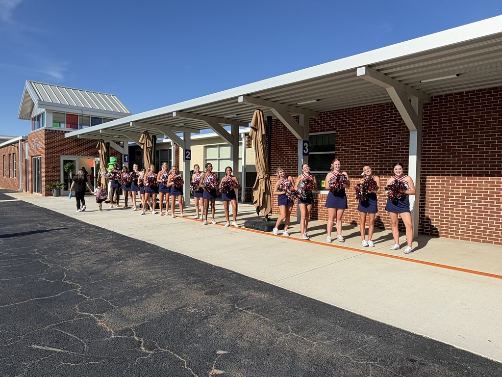 Cheerleaders line the front entrance to the school welcoming families for curriculum night