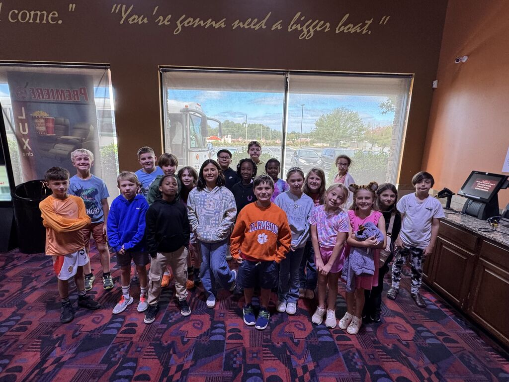 class of 4th graders posing for class picture at movie theatre 