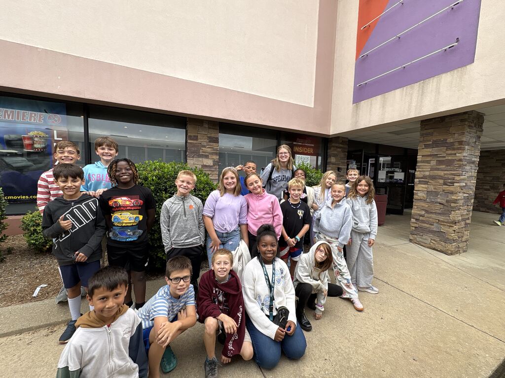 group of students pose for a picture outside of the movie theatre