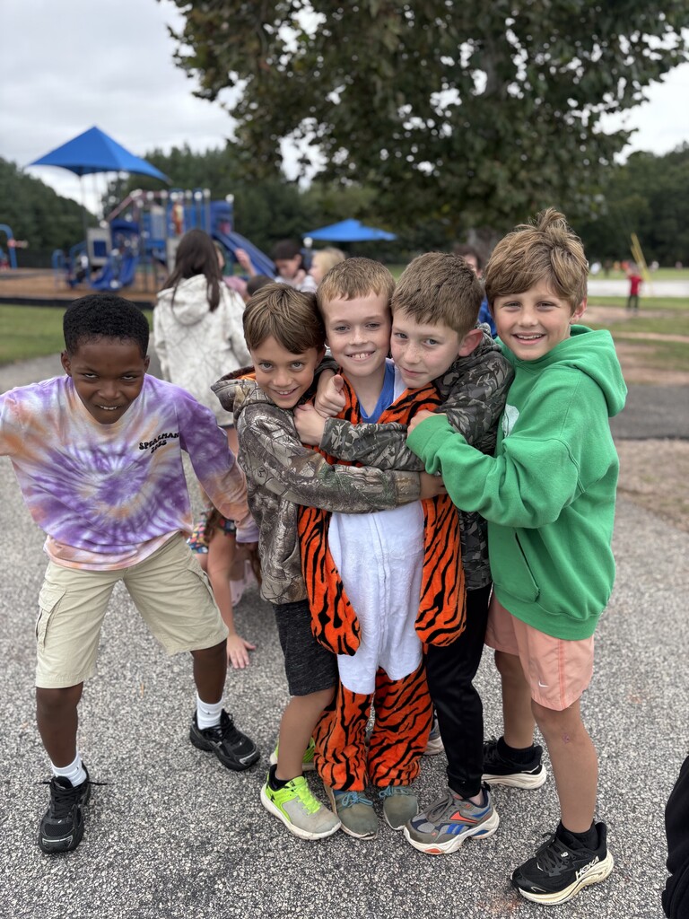 a group of 5 boys pose for a picture outside on Tiger Rising day