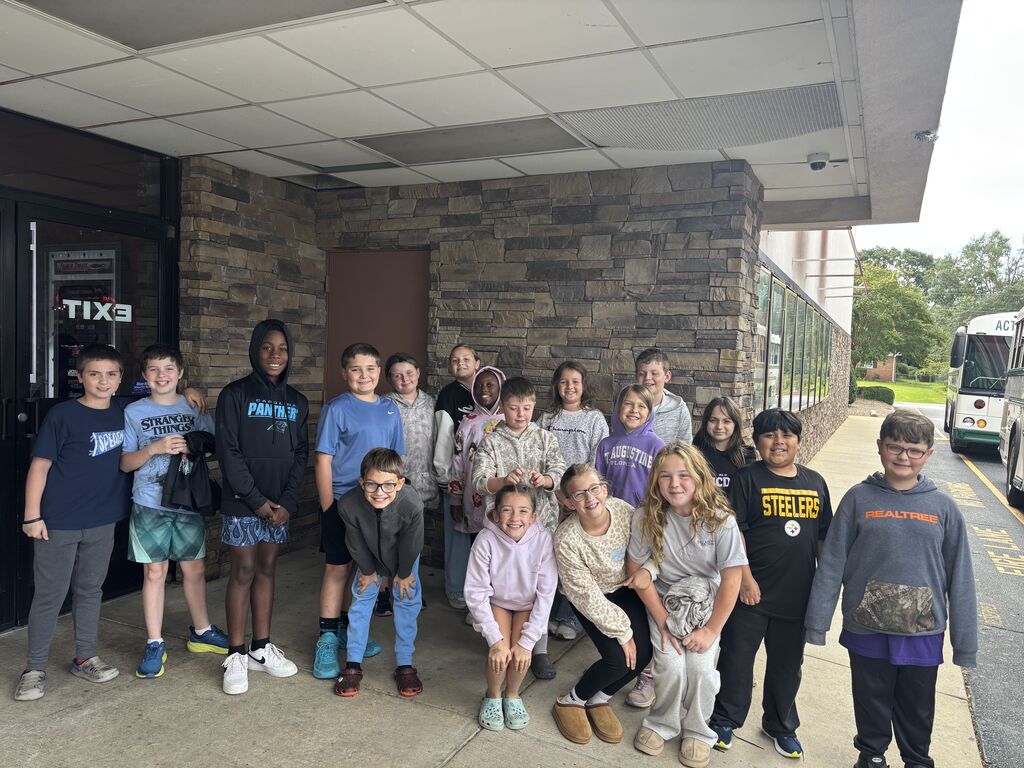 group of student pose for a picture outside of movie theatre 