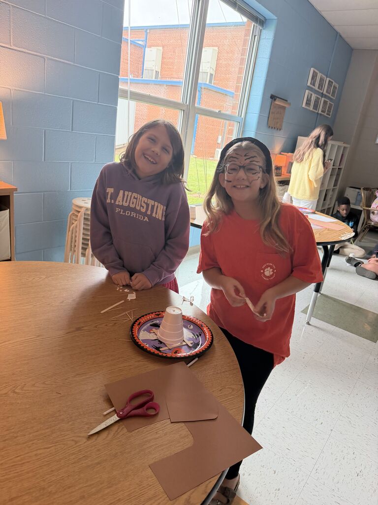 2 students smiling while doing a craft on Tiger Rising day