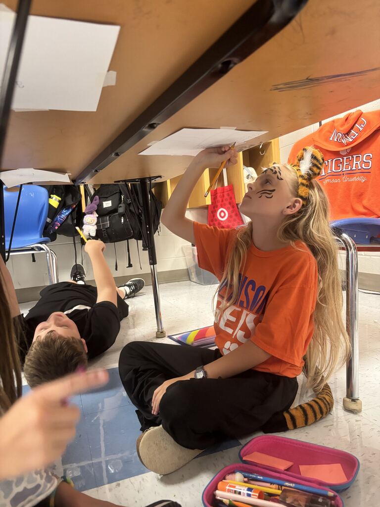 2 students writing under the desk for Tiger Rising Day