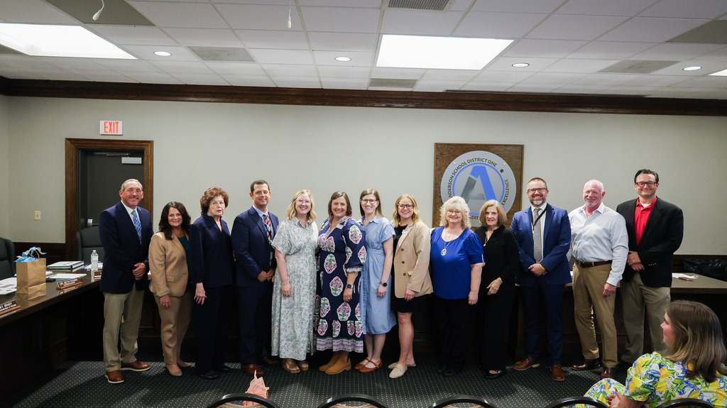 The school board, district staff, and digital learning coaches pose for a picture during a board meeting after the coaches were recognized for their positive impact on students