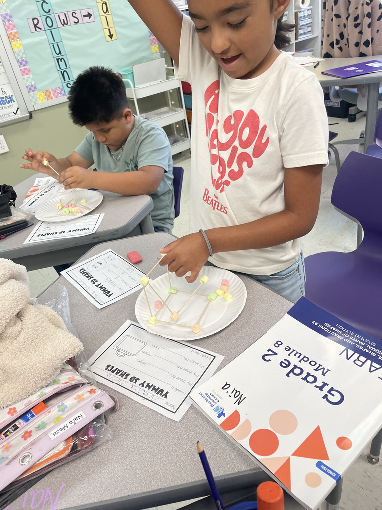 Engineering or snacking? In Mrs. Aaron’s 2nd-grade math class, it’s a bit of both! Our students are moving beyond the textbook to build 2D and 3D shapes from the ground up. By using marshmallows and toothpicks to represent vertices and edges, these young mathematicians are gaining a deeper understanding of geometric properties. Way to go, Grade 2!