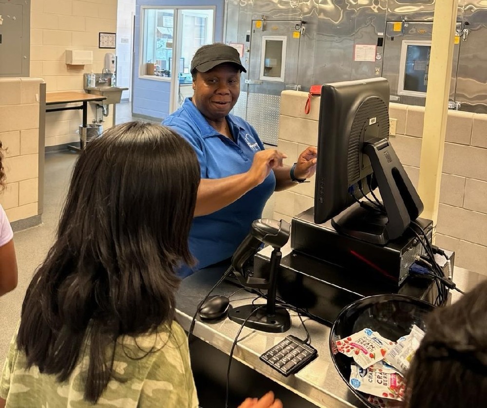 Food and Nutrition Services worker with student in lunch line