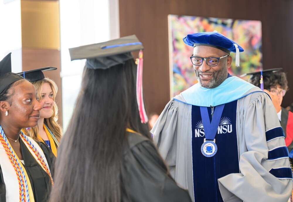 Superintendent Dr. Mark Bedell talks with student at graduation