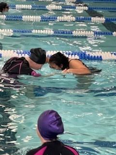 Student and instructor in the pool blowing bubbles.