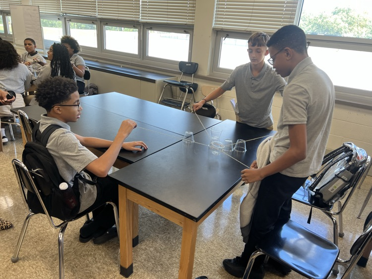 three students each holding a string attached to loop