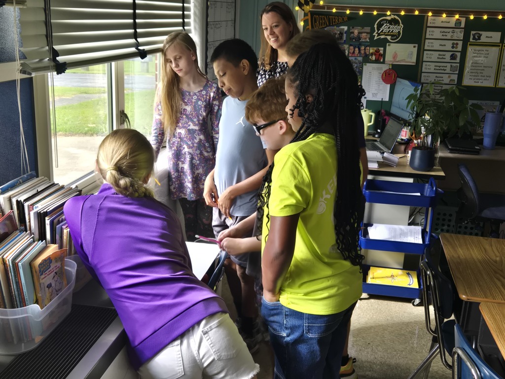 Students working together as teacher looks on