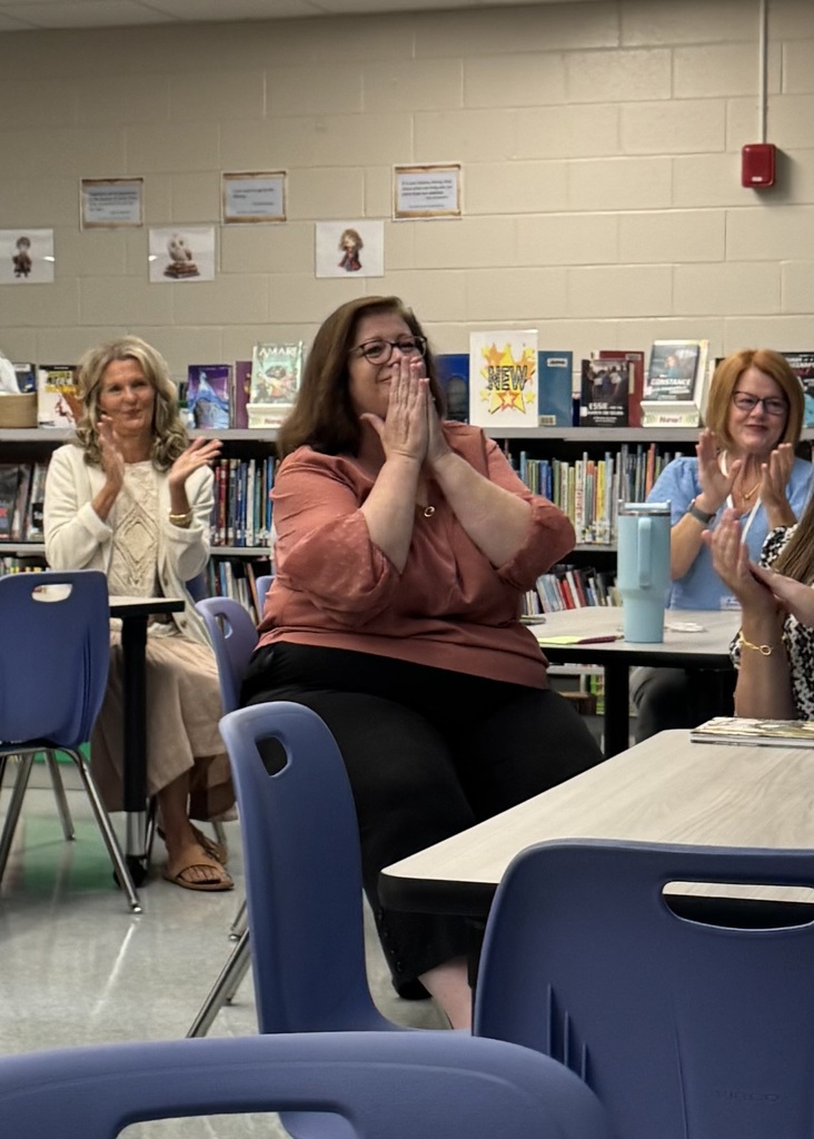 teachers sitting in the media center clapping 